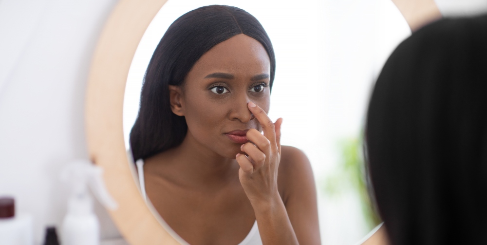 woman looking at her nose in the mirror